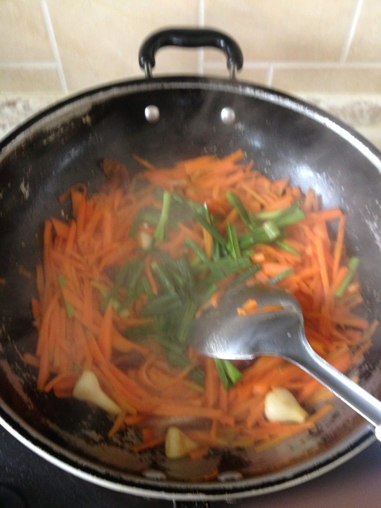 红萝卜炒大蒜叶,如图，加少量水，烧干加大蒜叶，味精
