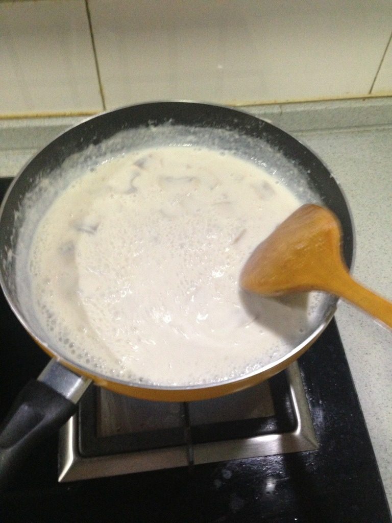 奶油蘑菇汤,锅中放入黄油，牛奶，少加一点水，放入蘑菇，三四分钟后放入奶酪和浓汤宝，如图