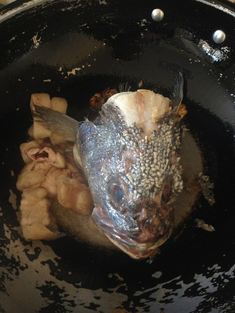 鱼头豆腐汤,如图，锅里热油，放入大蒜，鱼头等。