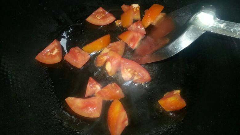 海鲜汤,油锅烧热放下姜片爆香、再倒下番茄粒翻下。