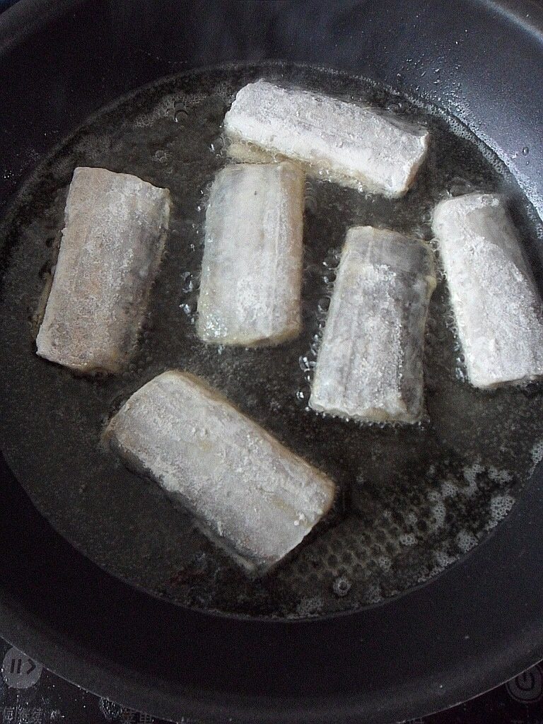 干烧带鱼,如图锅中油热后将裹好粉的带鱼放入锅中煎炸至两面金黄即可捞出