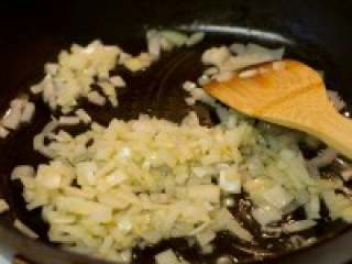 西班牙海鲜饭,平底锅加入适量橄榄油，入洋葱碎跟大蒜碎炒至洋葱透明