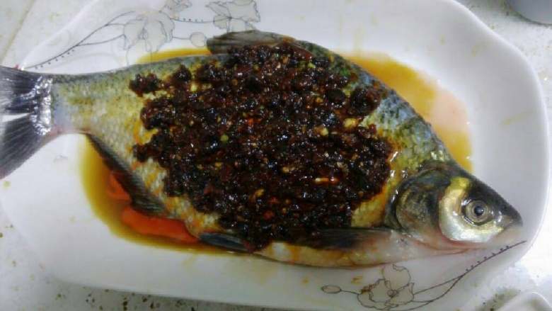 香辣豆鼓蒸武昌鱼,将炒好的香辣豆鼓酱汁均匀浇在鱼身上。