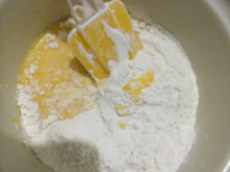 葡萄干戚风,蛋黄中加糖和油，搅拌均匀，再加一小部分牛奶，搅匀再加，直至都加完。筛入面粉，拌匀。注意不要画圈搅拌