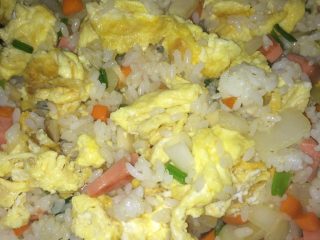核桃仁炒饭,炒至圆葱飘香时，倒入米饭，翻炒，打散饭团，均匀后加鸡蛋，适当放调料，盛到盘子里。