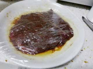 黑椒牛排,将牛排盖保鲜膜放入冰箱，腌制2小时左右。
煎牛肉前再涂抹一层干淀粉后再煎。