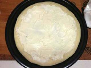 芝士榴莲披萨,取出饼，把室温软化的奶油奶酪均匀的抹在饼上
