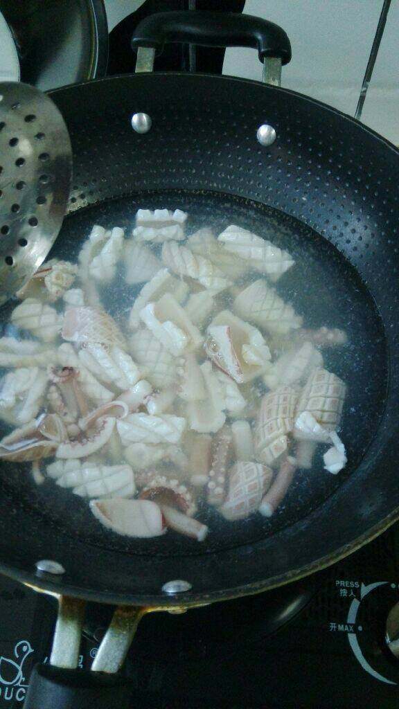 蒜苔炒鱿鱼,锅中烧水，水开后下入鱿鱼