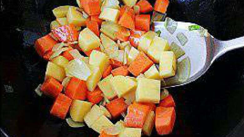 黄金咖喱猪扒饭,洋葱爆香后，将胡萝卜和土豆一起下锅煸炒。