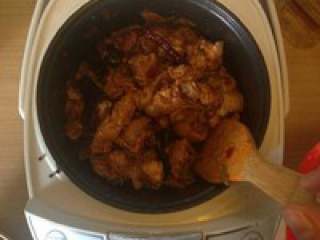 电饭锅版大盘鸡,倒入处理好的鸡肉翻炒，与酱料翻滚均匀融合。