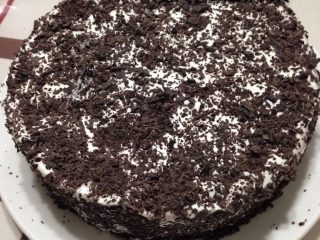 黑森林蛋糕,如图面上均匀抹上淡奶油，撒上巧克力碎削。