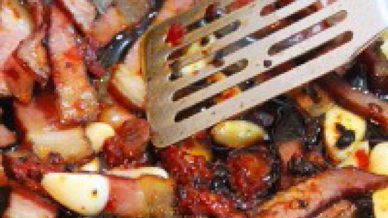 干锅土豆,炒锅内放入少许油，油热后放入腊肉片煸炒，随后放入蒜片、辣椒、老干妈煸炒出香味。
