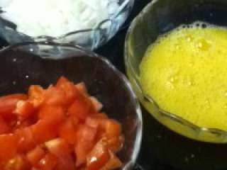 西红柿炒鸡蛋,将西红柿和洋葱分别切成丁，鸡蛋加入少许盐后打散。