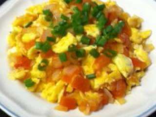 西红柿炒鸡蛋,炒匀后起锅，上面撒一些葱花即可享用。