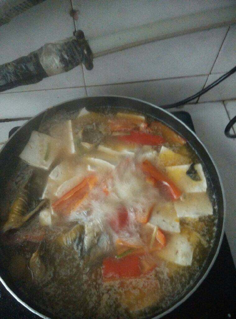 黄骨鱼豆腐汤,待煮开后，放入盛出的红椒等辅料，继续大火煮开，然后转中火煮十分钟