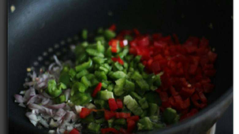 菠萝饭,锅内倒入橄榄油，待热后依次放入洋葱、青红椒翻炒片刻。