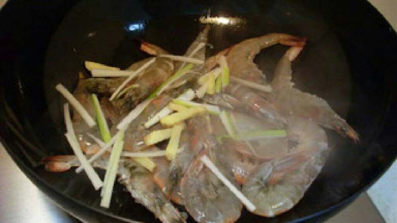 家常油焖大虾,待虾的一面变红后放入葱姜丝，然后翻面。