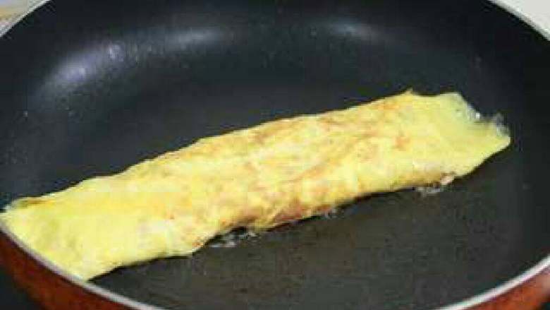 火腿番茄奶酪鸡蛋卷,关火，用余温让蛋卷两面再煎一会儿，确保里面的蛋液完全凝固后，盛出切成小段即可！
