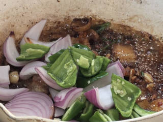 干锅菜花五花肉,加入洋葱和青椒片，炒匀