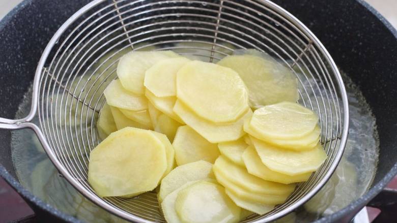 蚝油土豆片,锅中添水烧至沸腾，下入土豆片焯烫两分钟捞出过凉水。