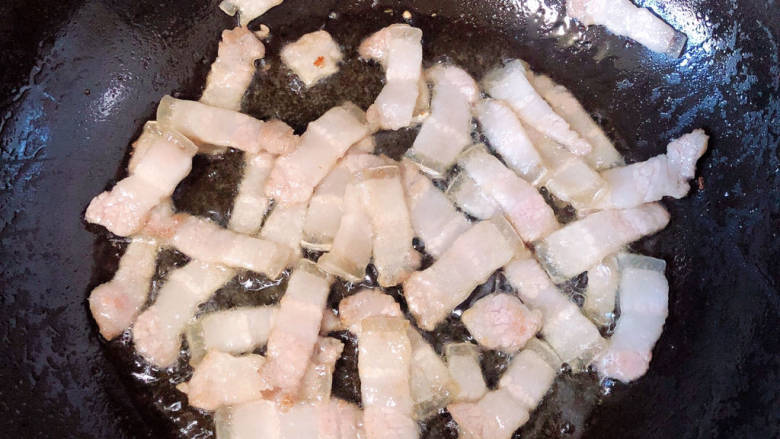 蒜苔五花肉,锅中倒入少许油，加热至五成热，放入五花肉煸出油。
