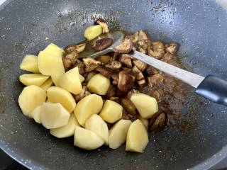 土豆香菇焖鸡,加入土豆块香菇，翻炒一分钟