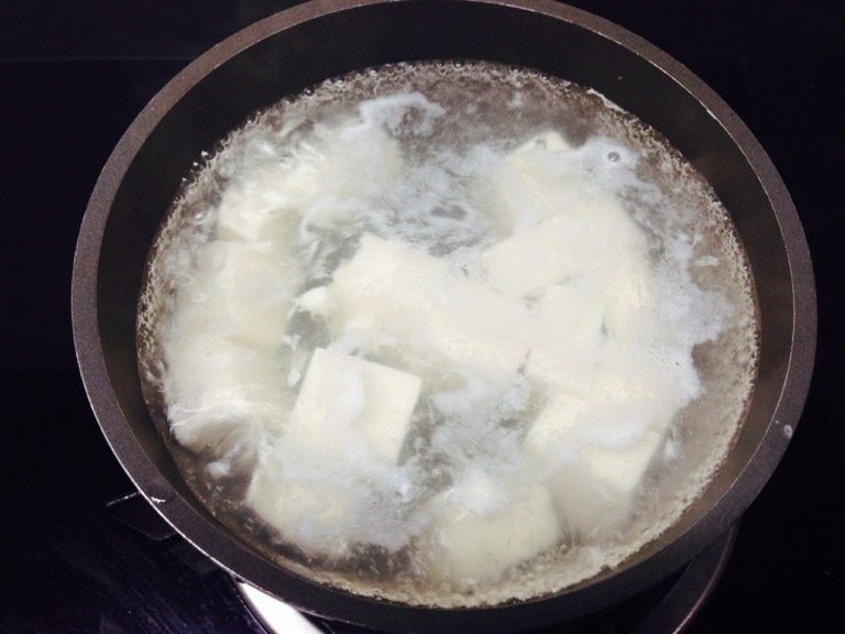 蟹粉豆腐,豆腐切成大约1.5厘米见方小块备用；锅中放入清水煮开，加一勺盐，关火后下豆腐略烫后捞出，过冷水晾凉；