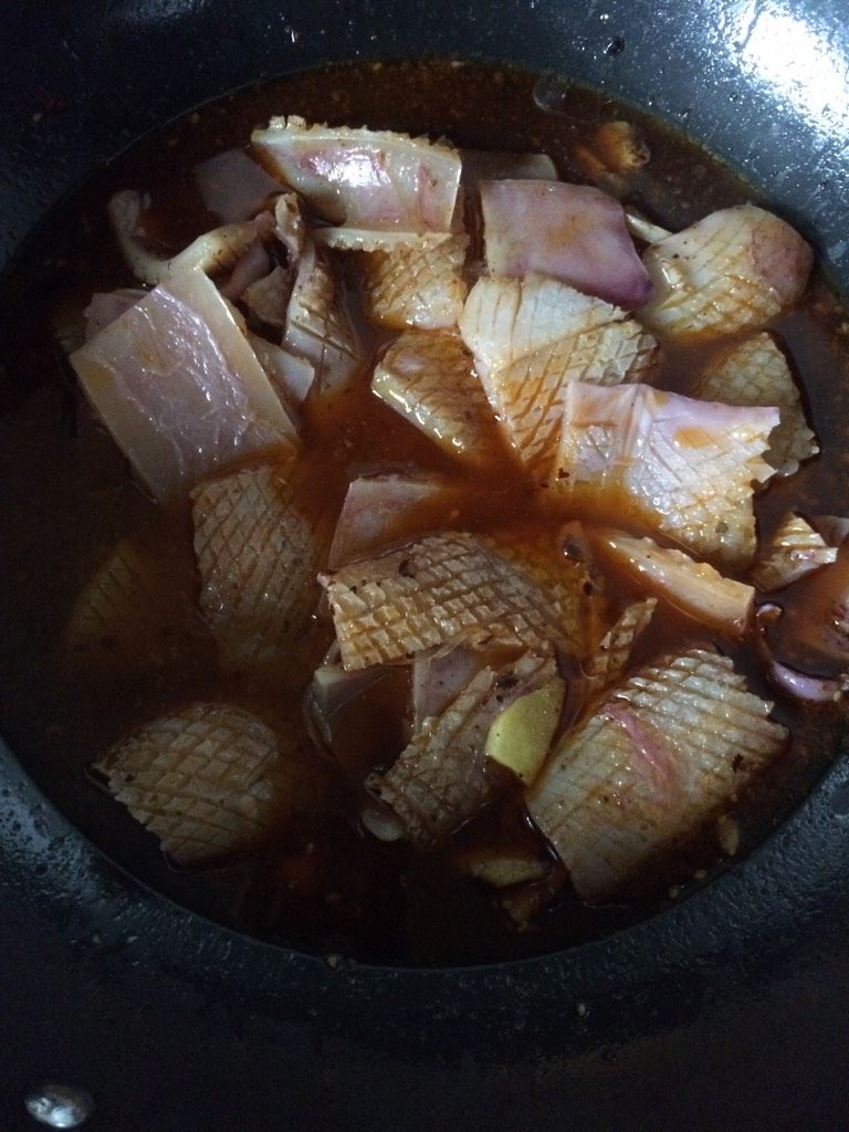 酱烧鱿鱼,如图水开后下入鱿鱼片，加盖焖煮