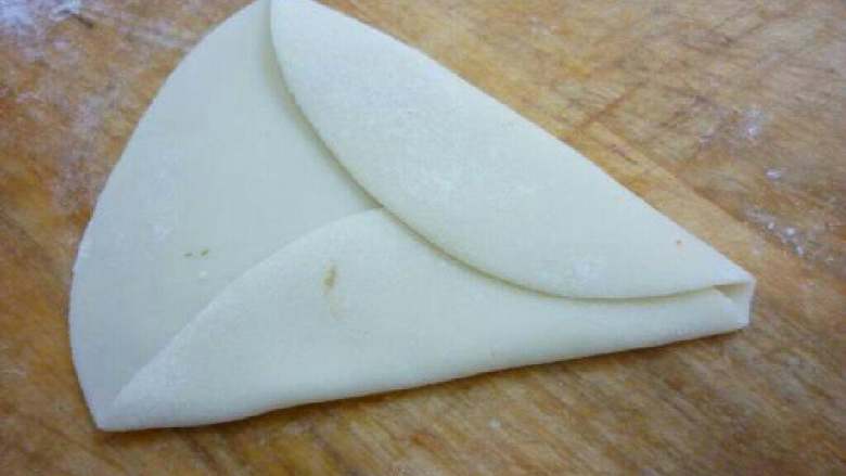 蝴蝶蒸饺,2.如图所示将面皮的两边卷上来，留下小半边不卷。
