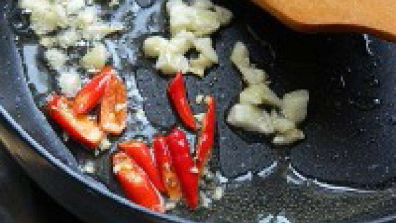 墨鱼炒韭菜花,热锅下油依次加入蒜末、辣椒煸炒出香味。