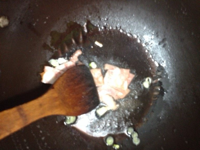 海鲜炒面,如图锅里放油，放入培根