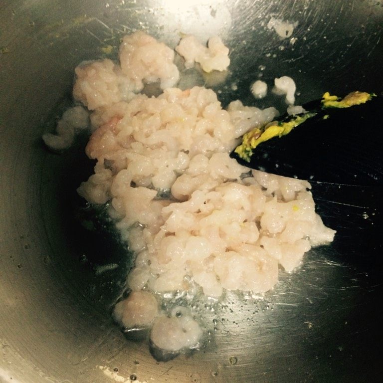 培根虾仁炒蛋,如图锅中再倒入少许油，下腌制好的河虾仁煸炒，至虾仁全部变色、粒粒分开；