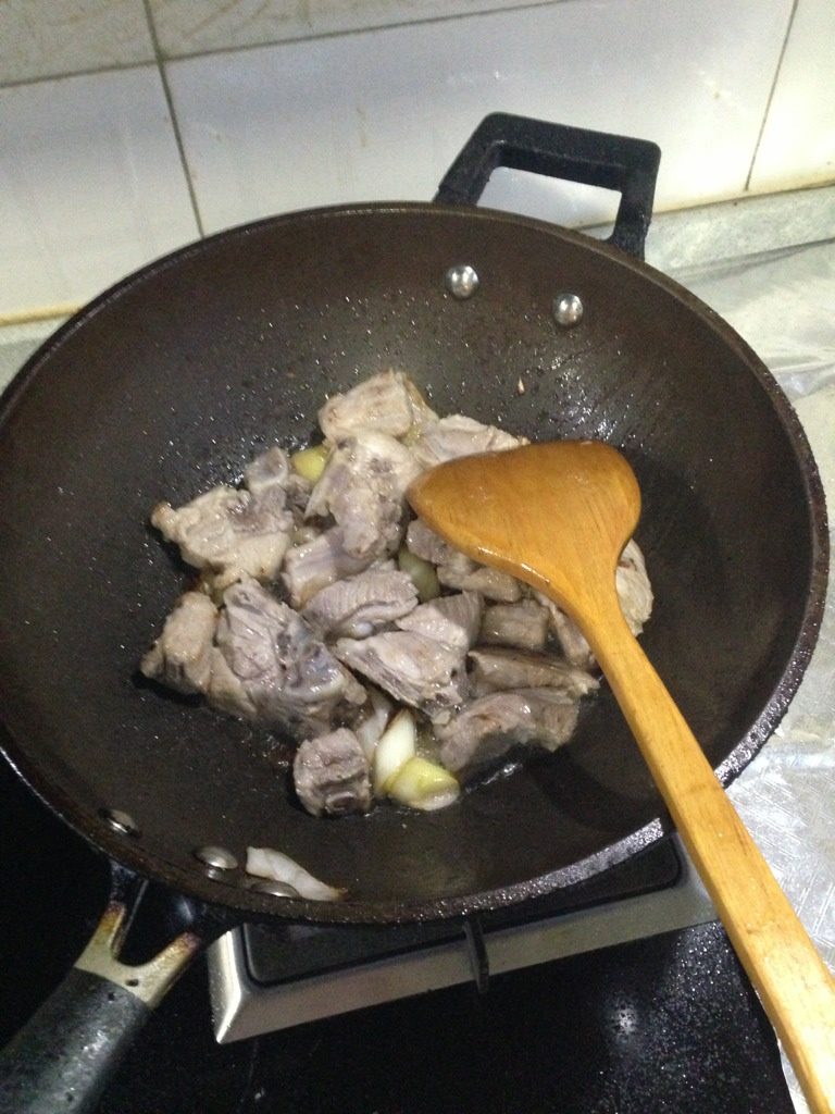 排骨豆角,洗净后，锅热油，放入葱姜，把排骨放里炒一下，如图