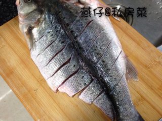 麻辣烤鱼,如图将鲈鱼洗净，对半切开，在鱼面上，滑几刀。