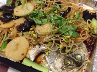 麻辣烤鱼,如图黄瓜切条，铺在烤盘上，把煮好的食材浇在烤鱼上，撒上香菜即可。