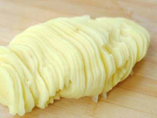 酸辣土豆丝,将土豆切成整齐的大薄片，这是切出均匀的丝的要点。