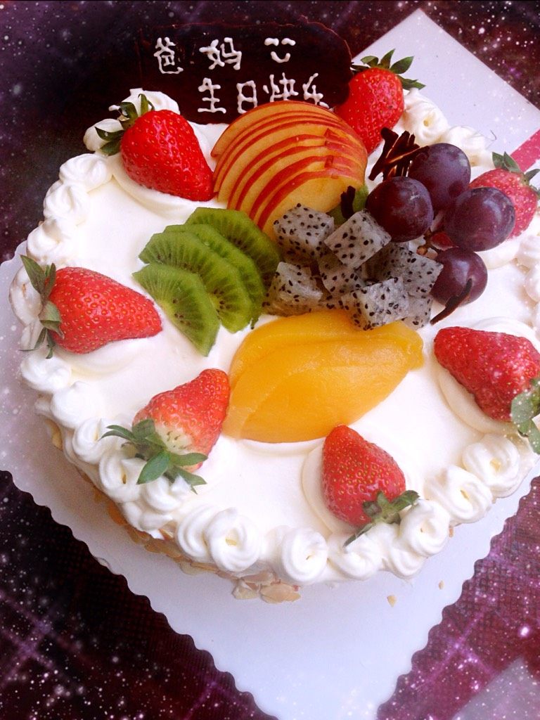 水果生日蛋糕,在蛋糕体周围沾上熟的杏仁片摆上水果造型即可