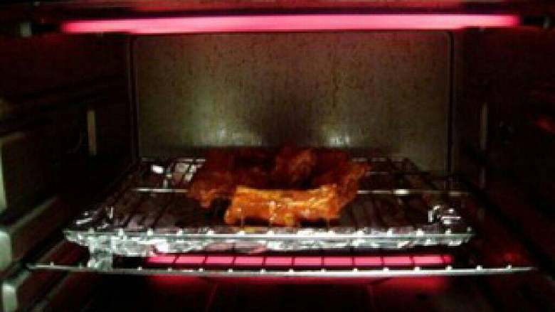 叉烧排骨,把烤箱设定220度，预热5-10分钟，然后把烤架放入烤箱内的中层，用上下火220度炉温进行烘烤。