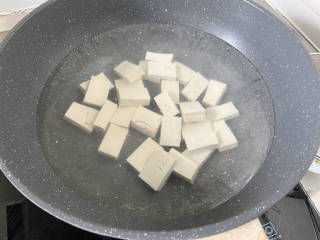 红烧草鱼块,坐锅烧水，水开加少许食盐，下豆腐块，再次煮开捞出