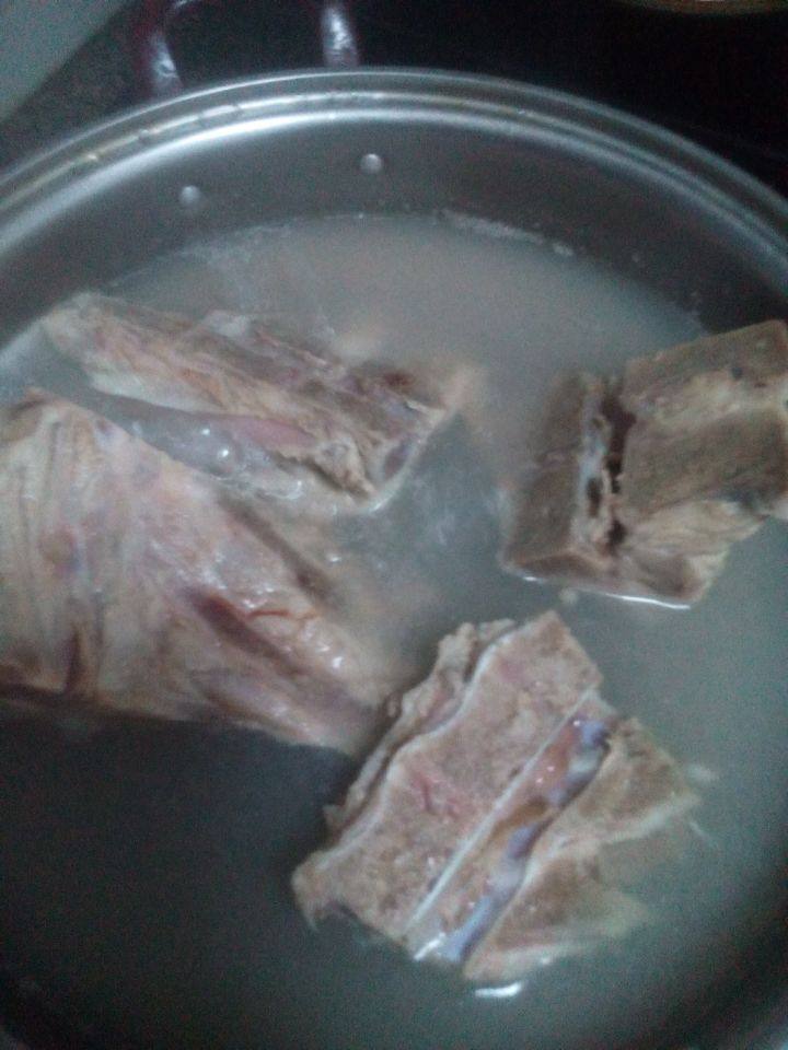 猪脊骨炖土豆豆角,水烧开后翻入脊骨煮一会， 捞出，用清水洗净白末。