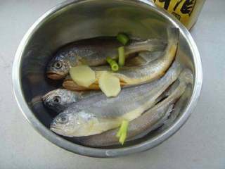 红烧小黄鱼,码入料酒、姜片腌制片刻去腥,捞出沥干水分。