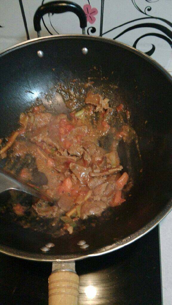 牛肉西红柿汤面,加入西红柿丁翻炒至西红柿起沙