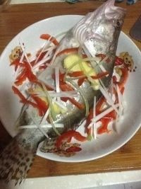 清蒸鲑鱼,将生姜、大葱和红辣椒切好，放入盘中
