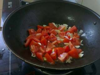 西红柿鸡蛋汤面,倒入西红柿块儿翻炒出汁儿；