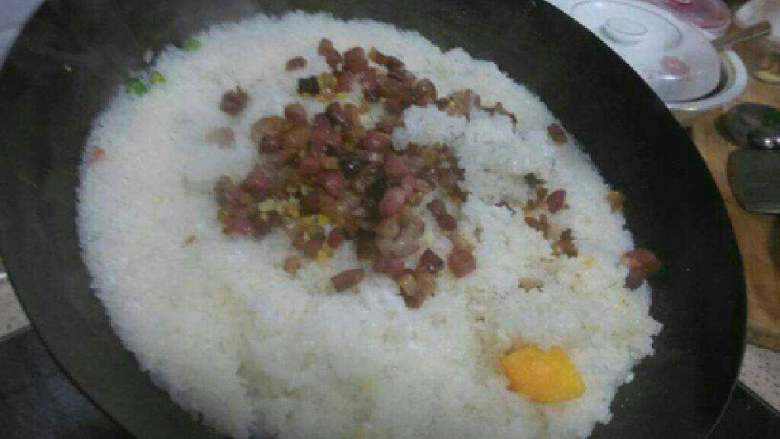 腊肉糯米饭,把煎好的腊肉丁铺在米饭上面，盖锅盖焖10分钟。