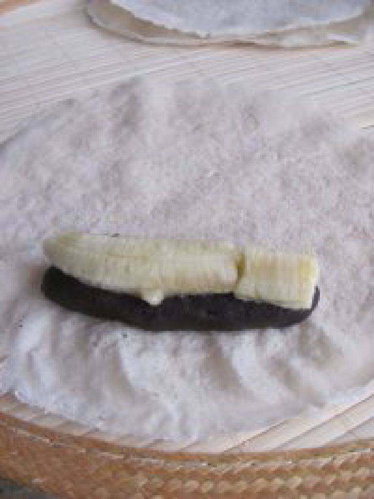 香蕉豆沙春卷,取一些豆沙馅放在春卷皮一侧，上面在摆放上一根香蕉条。