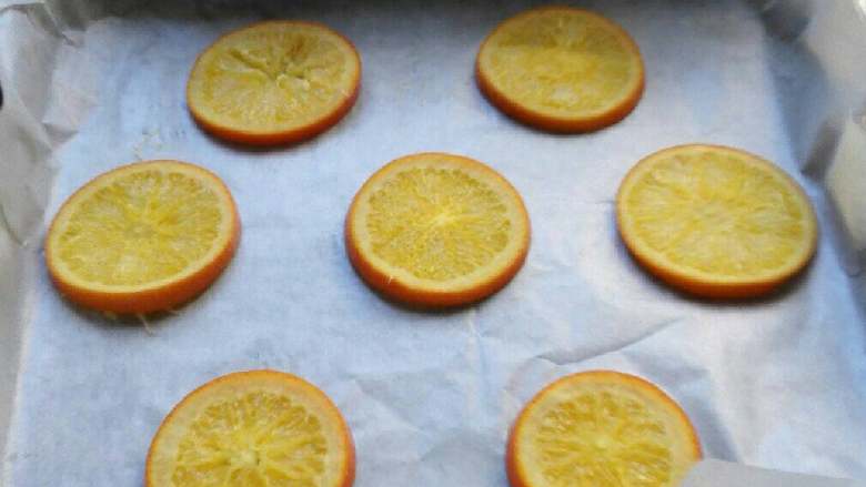 香橙蛋糕卷,烤箱150度预热。烤盘垫油纸，将橙片排在烤盘上。