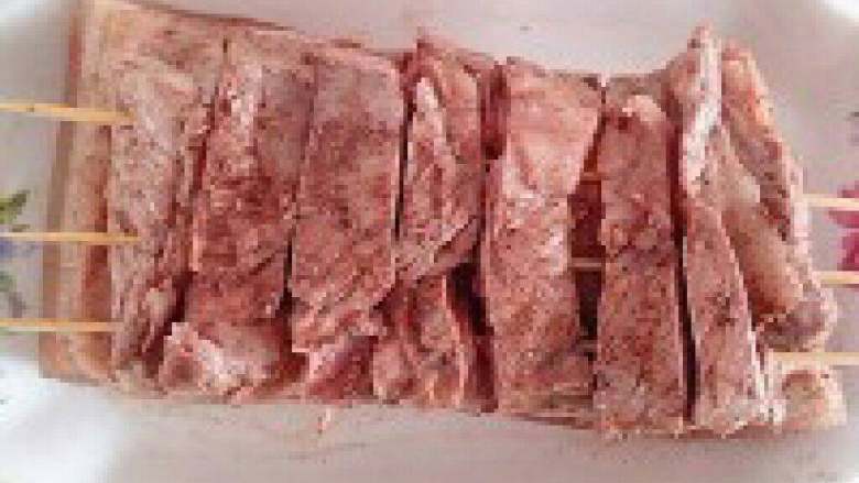 脆皮烧肉,  抹好后在肉的一面插入竹签，必须是插在肉的中间；以免烤的时候肉会卷起。