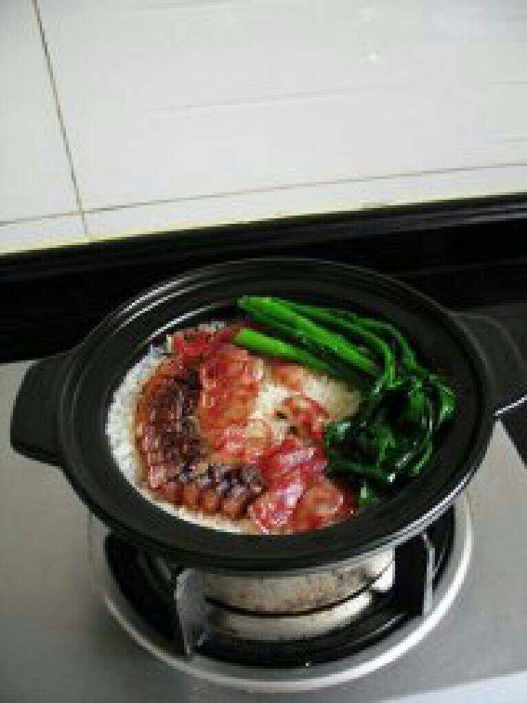 广式腊味煲仔饭,打开锅盖，放入青菜，大火煮1分钟左右。