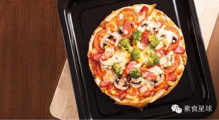 素食披萨,将烤盘放入已经预热的烤箱。 以上下火180°C烤10分鐘，至披萨